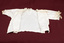 Child's lace trimmed, cream-colored blouse laid flat and opened at the front.