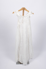 Front view of christening gown hung from wooden hanger