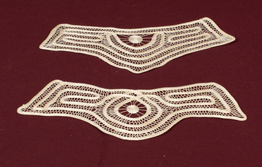 Matching lace cuffs with one cuff having a more rounded end.