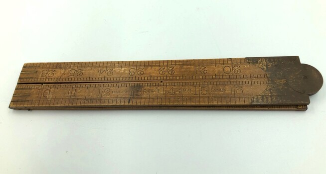 Folding rule closed with manufacturer's details visible.