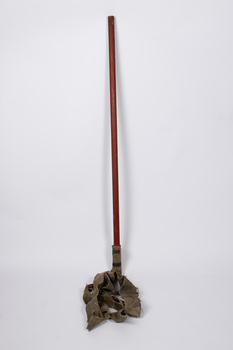 Front view of fire fighters beater showing long wooden pole with heavy duty textile straps attached.