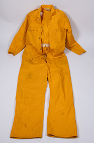 Yellow-colored fire fighter overalls laid flat