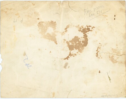 The rear of a photograph, with some writing in pen.