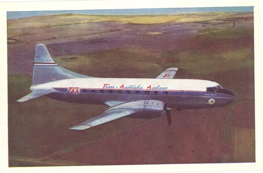Side view of TAA airline in flight over a predominantly brown landscape