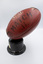 An Australian Rules football mounted on a stand in side view.