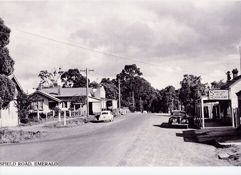 View down a street in black and white with shops either side.
