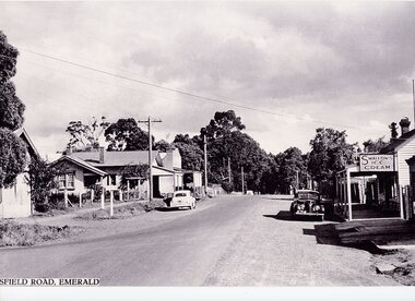 View down a street in black and white with shops either side.