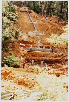 Concrete foundations laid on a steep descent into a gully with a new foundation with reinforcing mesh at the bottom as part of the rebuilding of the Puffing Billy line to Gembrook