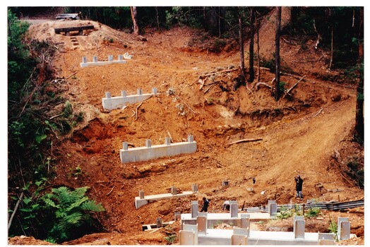 Parallel sets of concrete foundations that have been built across the contour to the bottom of a steep gully and up the other side - as part of the rebuilding of the Puffing Billy line to Gembrook.