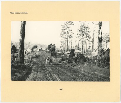 A black and white photograph of a dirt road at the center of a piece of paper.