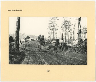 A black and white photograph of a dirt road at the center of a piece of paper.