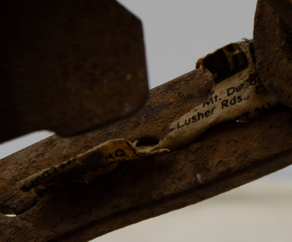 Close-up view of newspaper scrap caught between jaws of rabbit trap