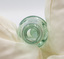 Empty glass bottle captured looking into the opening, with a glass marble visible inside.