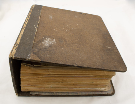 A closed manual, looking down at an angle to capture the cover and the bottom edges of pages.