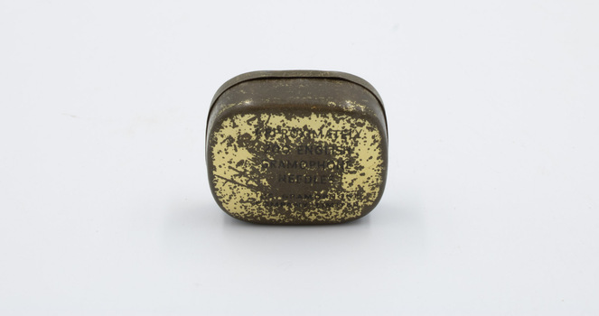 The reverse of a tarnished metal container with printed text.