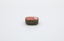 A metal container with red decoration on top, focused on the point where the tin opens.