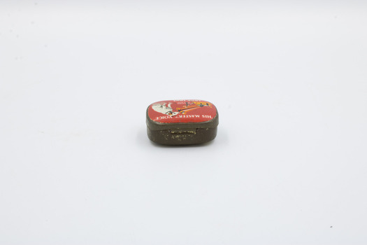 A metal container with red decoration on top, focused on the hinge on the side.