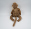 The back of a brown toy monkey with a zipper down the centre of its back.