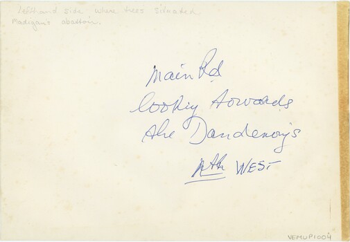 Reverse of a photograph printed on paper, with handwritten text in pencil and blue pen