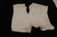 An aged set of white women's underwear, with stains and tears in the fabric.