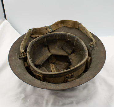Underside of tin helmet showing name label and strap.