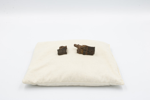 2 pieces of shrapnel purportedly striking the owner, Ian Stephen Macleod, on the helmet during the London Blitz in 1940