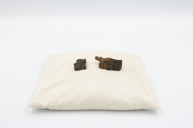 2 pieces of shrapnel purportedly striking the owner, Ian Stephen Macleod, on the helmet during the London Blitz in 1940