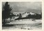 A black and white photograph of a field and hill covered in a layer of snow.
