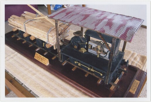 The obverse of a colour photograph picturing a model of an old rail tractor.