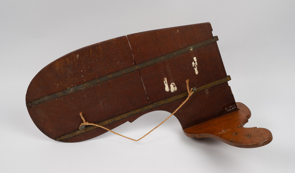 Back and upside-down view of the rudder showing a cord for hanging the rudder for display.