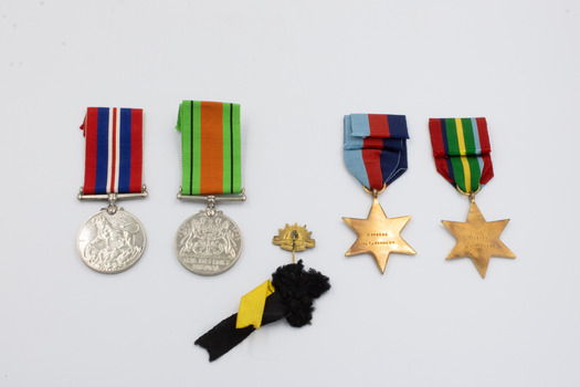 The reverses (tail or rear side) of the five medals detailed in this entry, arranged left-to-right a, b, c, d, e.