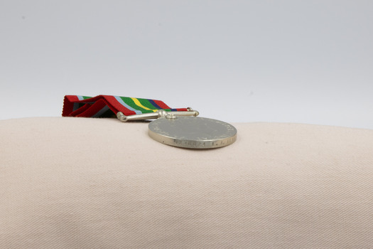 The edge of b, the newer Australia Service medal, showing inscribed text.