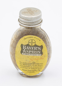 Front of medicine bottle showing 'Bayer's Aspirin' and other information on a label with yellow background