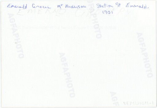 The reverse of a printed photograph, featuring handwritten text in pen and pencil.