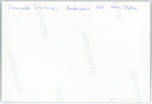 The reverse of a printed photograph, featuring handwritten text in pen and pencil.