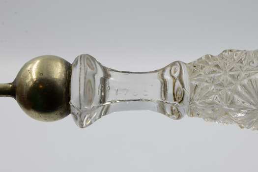 Close-up image of cut glass Chippendale handle of salad serving fork