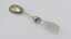 Salad serving fork in prone position with glass handle in foreground.