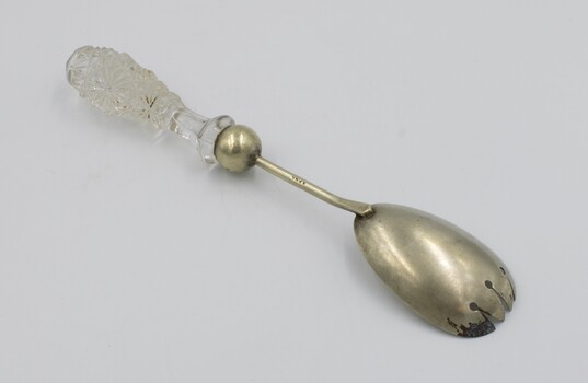 Salad serving fork in prone position with fork end in the foreground.