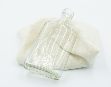 Empty O'Cedar bottle propped on cusion