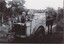 A black and white photograph of three children on the back of a horsecart.