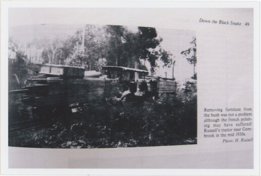 A photograph capturing a book page, itself containing a black and white photograph and printed caption text.