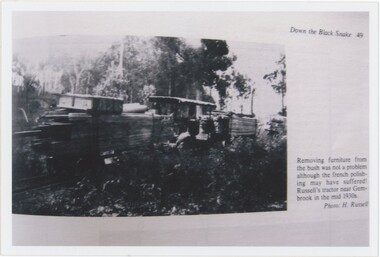 A photograph capturing a book page, itself containing a black and white photograph and printed caption text.