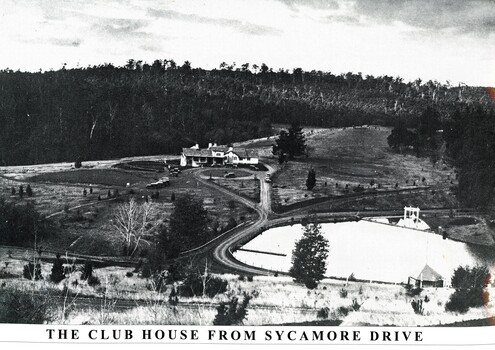 Emerald Country Club club house in centre of image with ornamental lake in the foreground to the right.