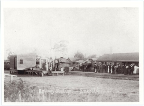A black and white photograph of a train station crowded with people with a written caption at the bottom.