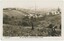 A sepia postcard, featuring a view from the top of a hill looking over a landscape of rolling hills with fields and a nursery.