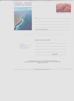 Front of aerogramme laid out showing photograph of Australian coast and a 'stamp' illustration of red rocks.