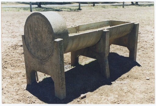 A colour photograph of a concrete trough, viewed from an angle with a raised section in the foreground.