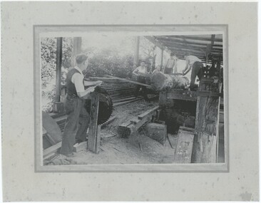 A printed black and white photograph of five men working at a sawmill.