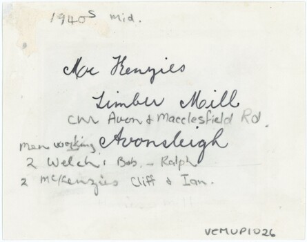 The reverse of a printed photograph, with significant handwritten annotation in pen and pencil. 