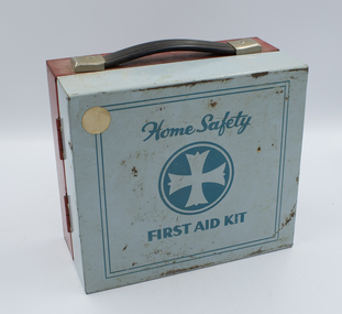 A square metallic first aid kit, facing the blue-painted front side with the red rear and a carry handle visible.